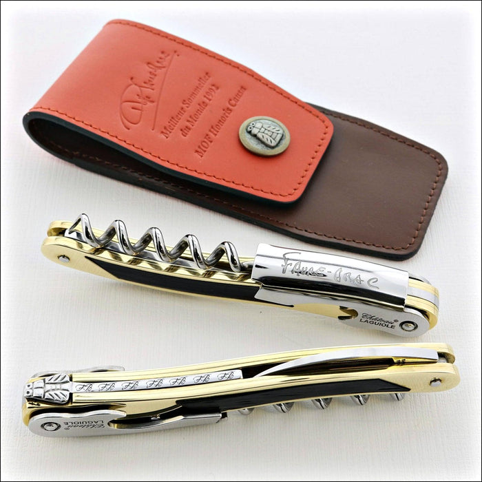 Chateau Laguiole Philippe Faure-Brac corkscrew, gold-plated with black accents, shown open with worm visible. Handcrafted details, 100% Made in France.