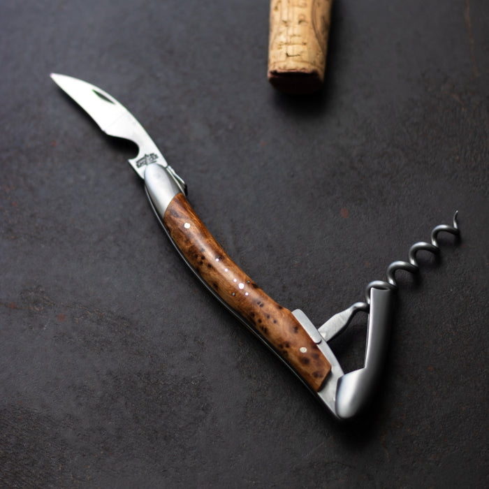 Forge de Laguiole Corkscrew Thuya: close-up of satin steel and polished thuya wood handle on dark stone.