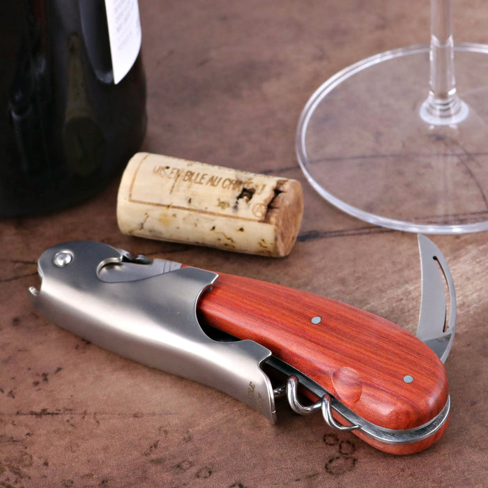 Laguiole Magnum Corkscrew, rosewood handle, stainless steel body, close-up with wine bottle and cork.